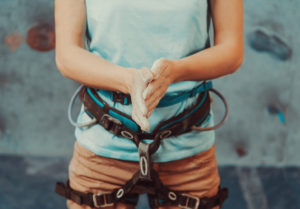 A person in a rock climbing harness fully prepared to get things done