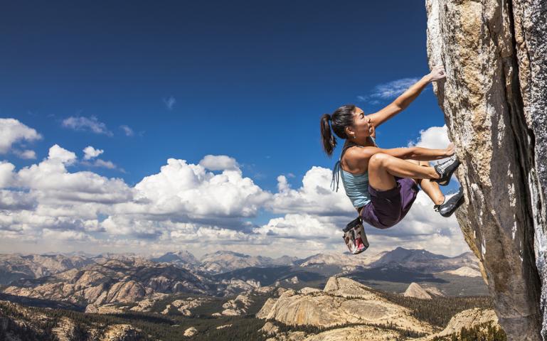 A woman free climbing a mountain 