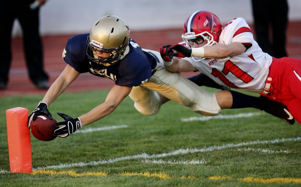 Diving for a touchdown while being tackled.